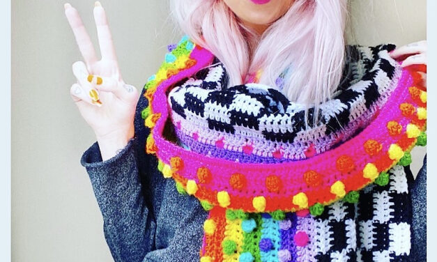 The ‘Raincheck Scarf’ Rainbows & Checkerboard Is The Colorful Cowl You Need To Chase Away Those Winter Blues